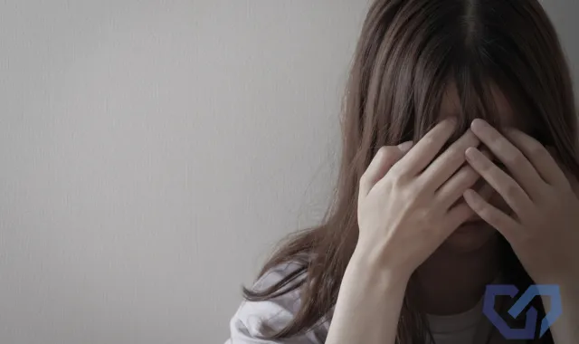 女性が顔を覆っている