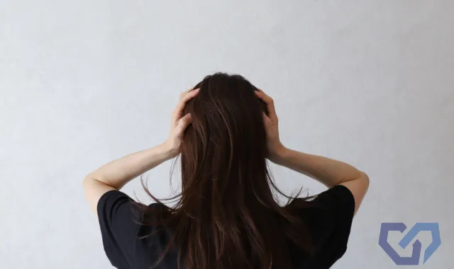 頭を抱える人の後ろ姿