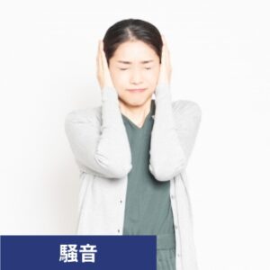 耳をふさぐ女性