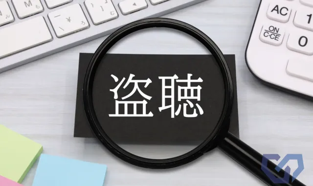盗聴と書かれた黒い紙を虫眼鏡で覗いている