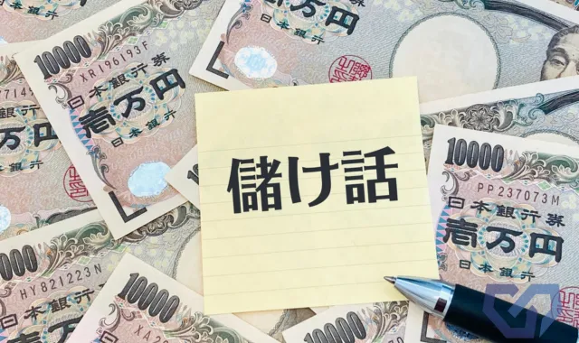 お札の上にもうけ話と書かれている紙