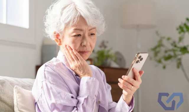 スマホを片手に悩んでいる祖母