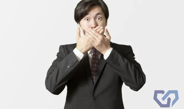 口を手で押さえている人