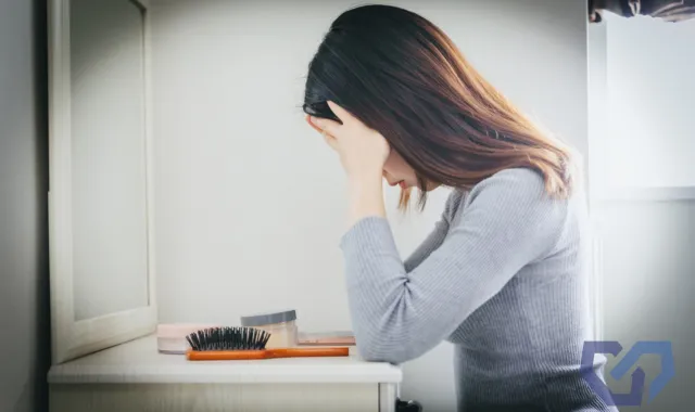 鏡の前でうつむく女性