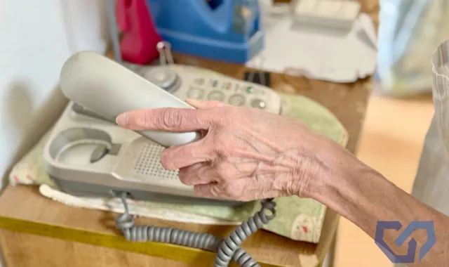 固定電話を取る手