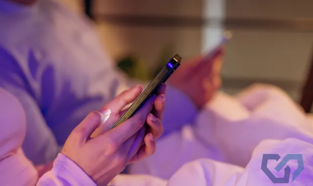 ベッドでスマホを操作する人