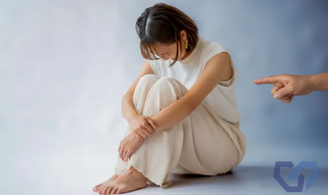 うずくまる娘と親の手