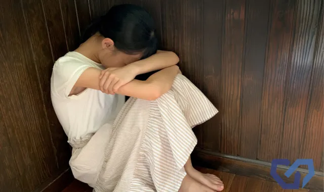 膝を抱えた女性